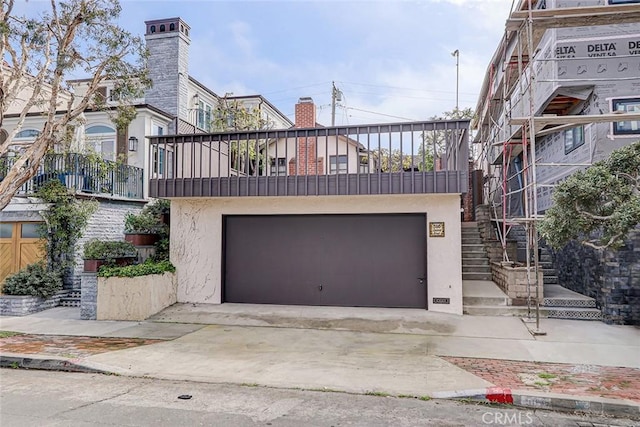 view of front of home with a balcony, driveway, a garage, and stucco siding