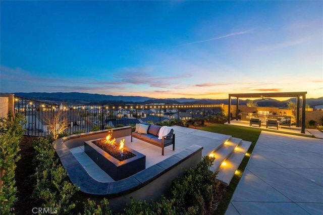 view of patio / terrace featuring fence and an outdoor living space with a fire pit