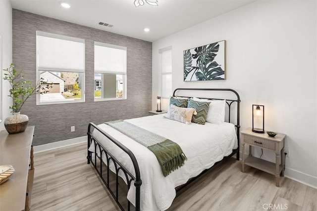 bedroom with recessed lighting, wood finished floors, visible vents, and baseboards