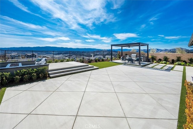 view of patio with a mountain view and fence