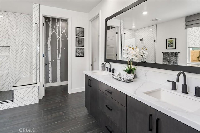 full bathroom with double vanity, a shower stall, visible vents, and a sink