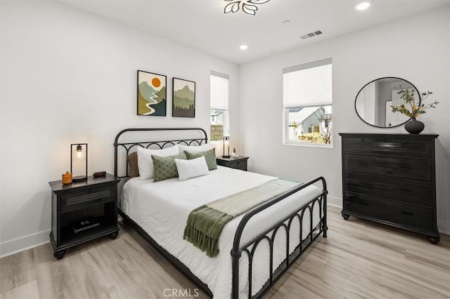 bedroom with baseboards, light wood-style flooring, visible vents, and recessed lighting