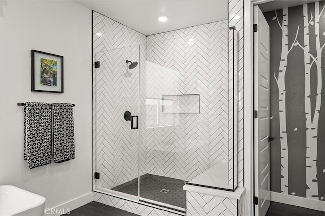 bathroom with a stall shower, recessed lighting, wood finished floors, and baseboards