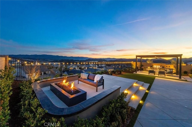 view of patio / terrace with an outdoor living space with a fire pit and fence