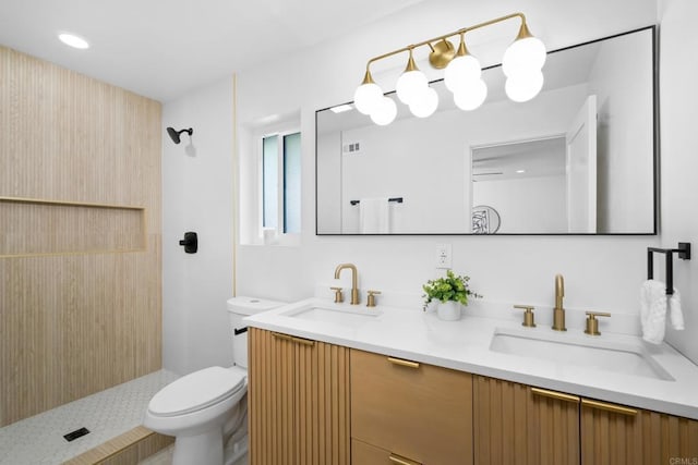 bathroom featuring double vanity, toilet, walk in shower, and a sink