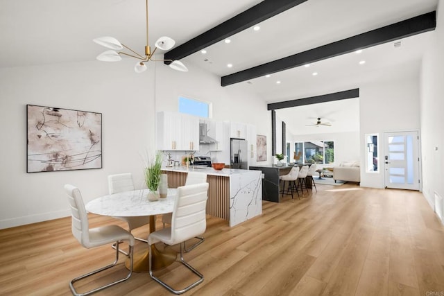 dining room featuring high vaulted ceiling, beam ceiling, and light wood-style flooring