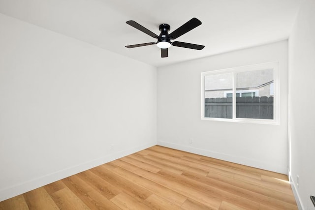 spare room featuring ceiling fan, wood finished floors, and baseboards