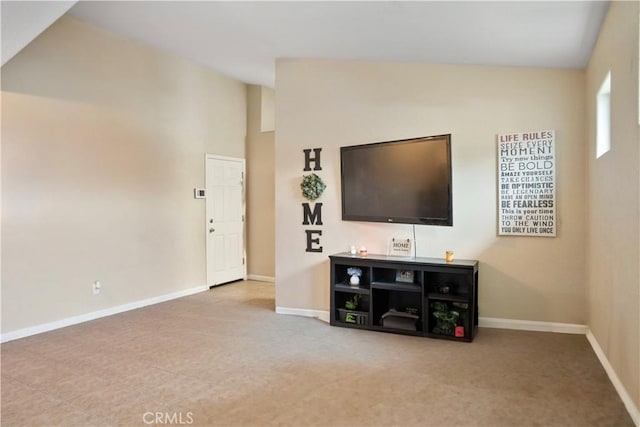 living area featuring lofted ceiling and baseboards