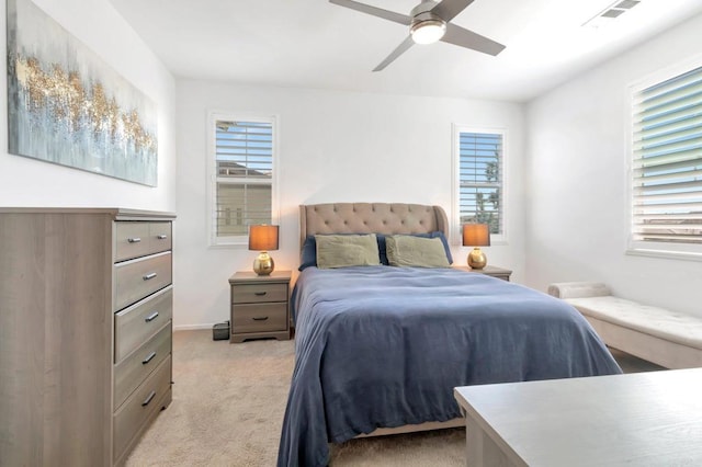 bedroom featuring a ceiling fan, visible vents, and light colored carpet