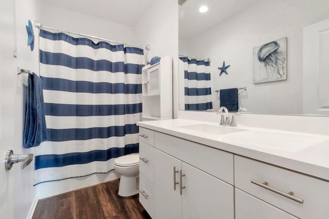 bathroom with recessed lighting, curtained shower, toilet, vanity, and wood finished floors