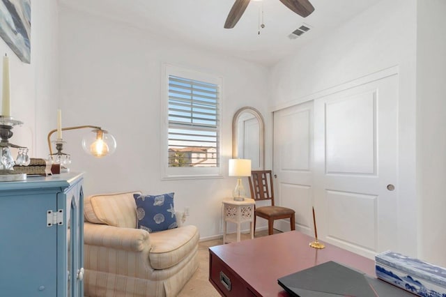 sitting room featuring visible vents, ceiling fan, and baseboards