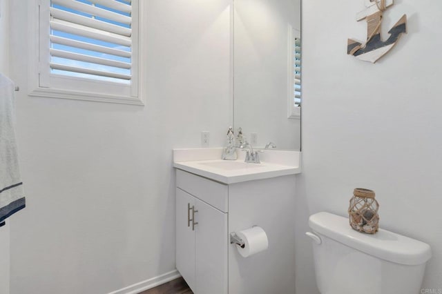 bathroom featuring vanity, toilet, and baseboards