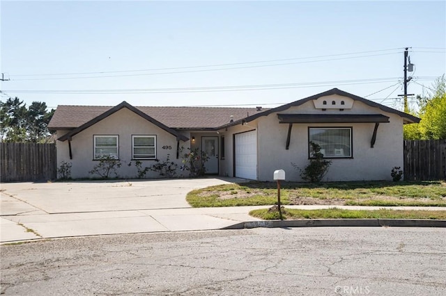 single story home with concrete driveway, an attached garage, fence, and stucco siding