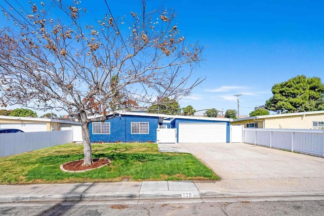 view of front of property featuring a front yard, concrete driveway, fence, and an attached garage