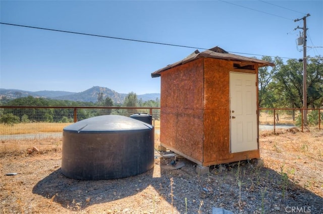 view of outbuilding with a mountain view and fence