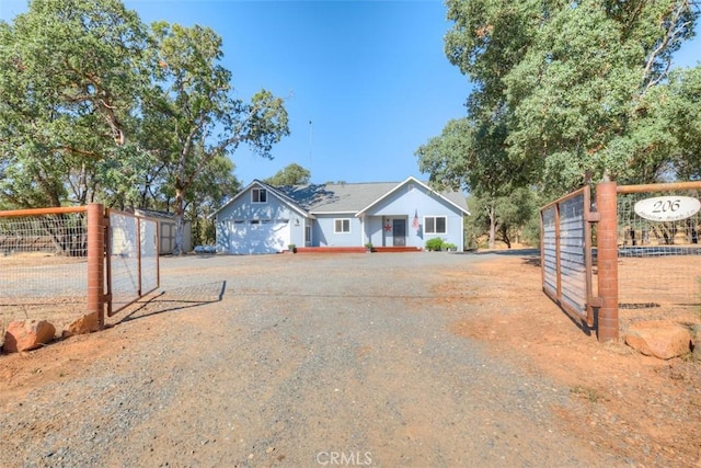 view of front facade featuring a gate, fence, and driveway