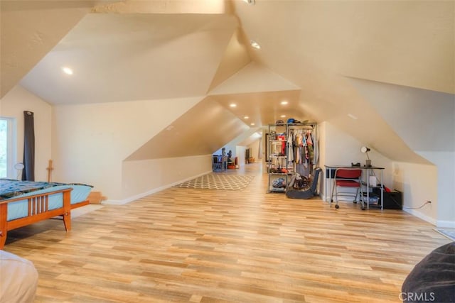 additional living space with lofted ceiling, recessed lighting, light wood-style flooring, and baseboards