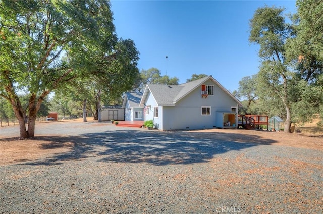 view of home's exterior featuring driveway, a storage shed, and an outdoor structure