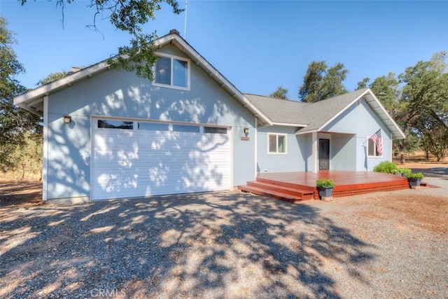 view of front of house featuring a garage, driveway, and a wooden deck