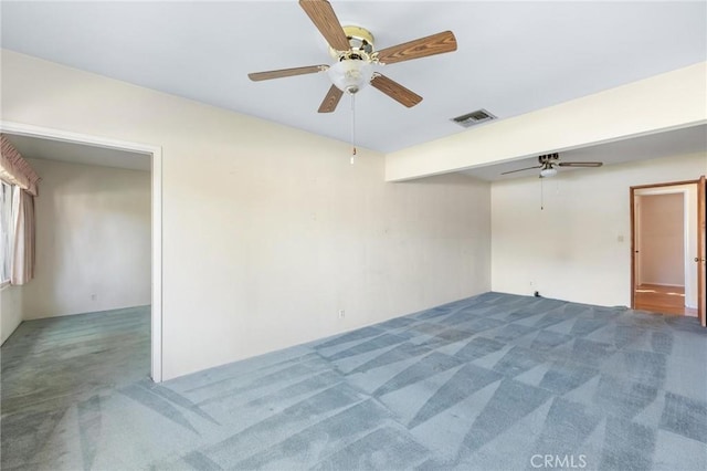 carpeted empty room with visible vents and a ceiling fan