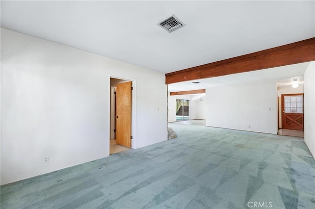 unfurnished room featuring visible vents, beam ceiling, and light colored carpet