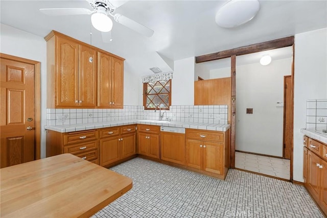 kitchen featuring brown cabinets, light countertops, and backsplash