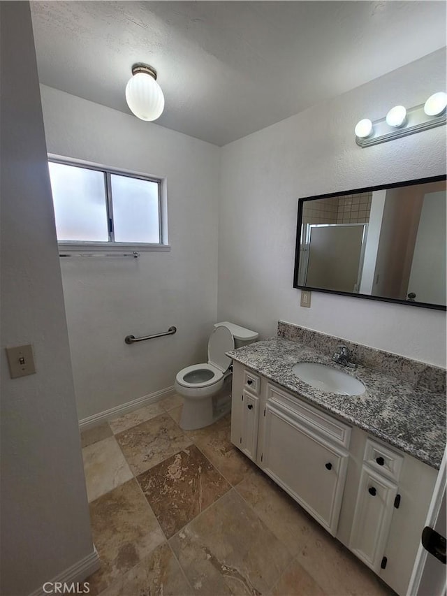 bathroom featuring toilet, baseboards, and vanity