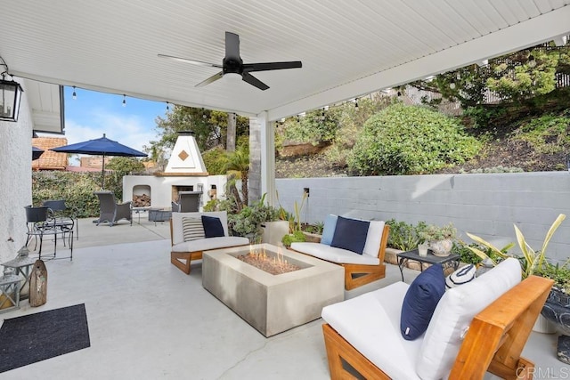 view of patio / terrace featuring an outdoor living space with a fireplace and a ceiling fan