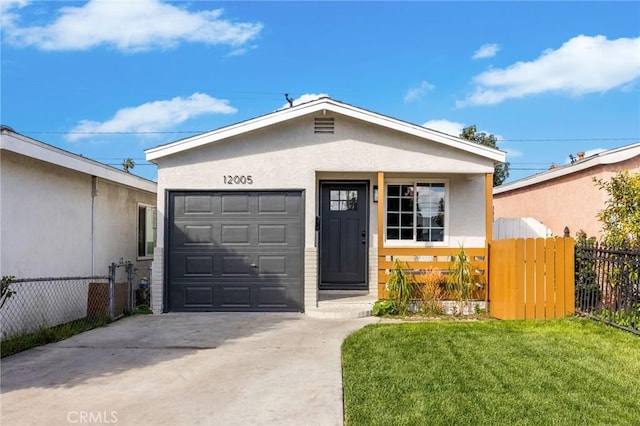 view of front of home featuring a garage, driveway, fence, a front lawn, and stucco siding