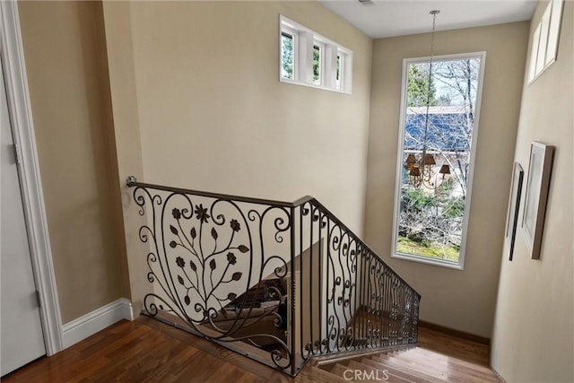 staircase with baseboards and wood finished floors