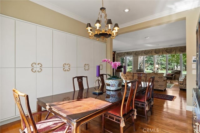 dining area with ornamental molding, recessed lighting, an inviting chandelier, and wood finished floors