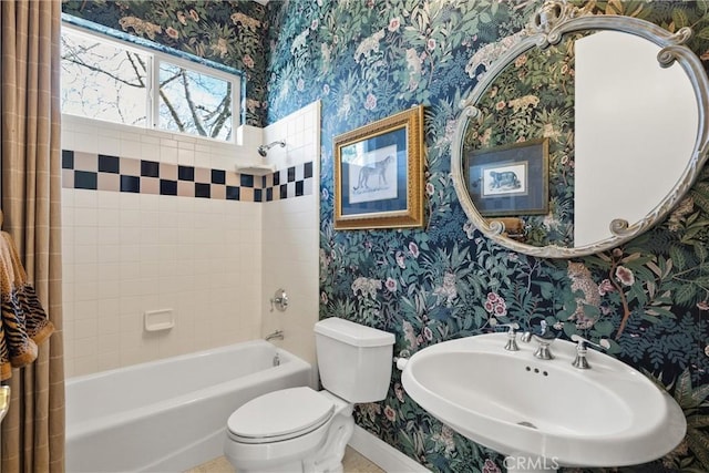 full bath featuring bathtub / shower combination, toilet, a sink, baseboards, and wallpapered walls