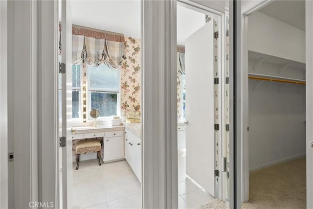 bathroom featuring tile patterned floors, a spacious closet, and wallpapered walls