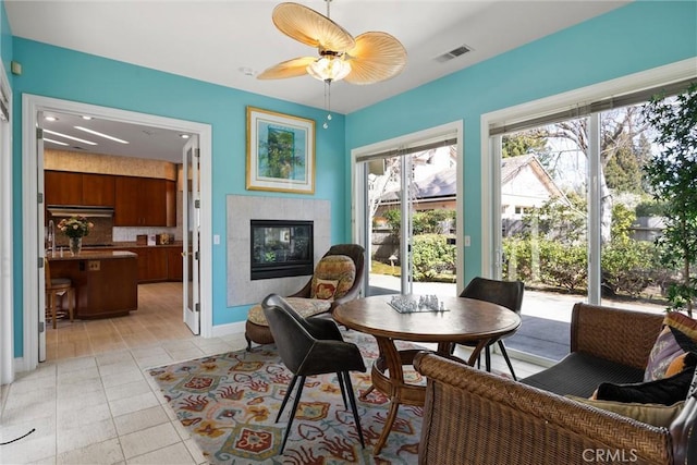 interior space with ceiling fan, a fireplace, and visible vents