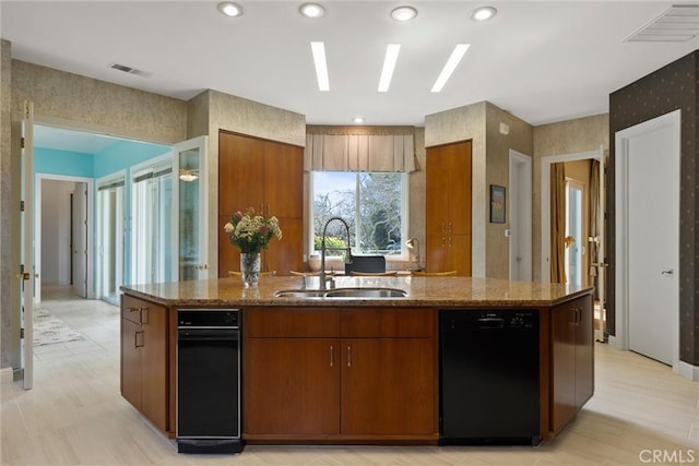 kitchen featuring black dishwasher, a sink, visible vents, and brown cabinets