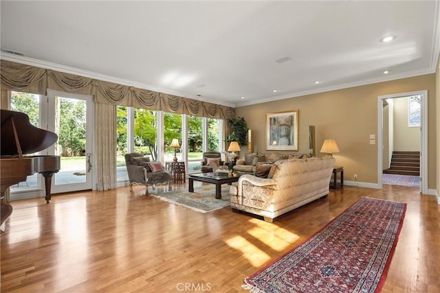 living room featuring recessed lighting, baseboards, stairs, light wood-style floors, and ornamental molding