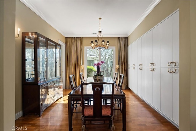 dining area with dark wood-type flooring, an inviting chandelier, and crown molding