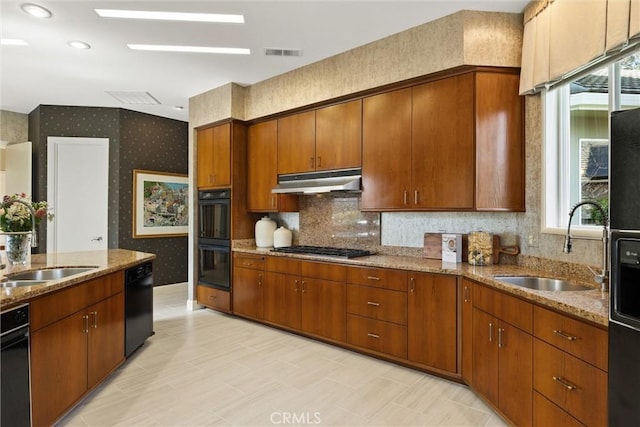 kitchen with visible vents, a sink, under cabinet range hood, black appliances, and wallpapered walls