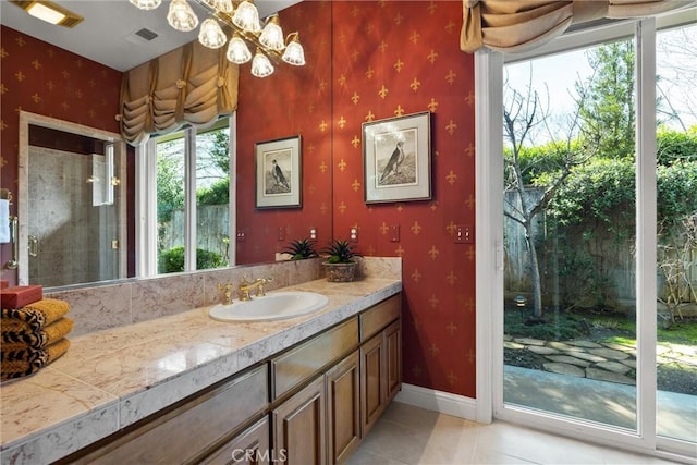 full bathroom with tile patterned flooring, vanity, baseboards, wallpapered walls, and an inviting chandelier