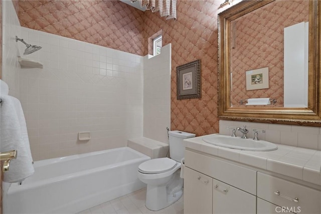 full bathroom with wallpapered walls, toilet, tile patterned flooring, vanity, and shower / bathing tub combination