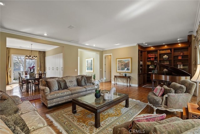 living area with wood finished floors, crown molding, baseboards, and an inviting chandelier