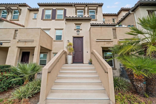 view of front facade with a tile roof and stucco siding