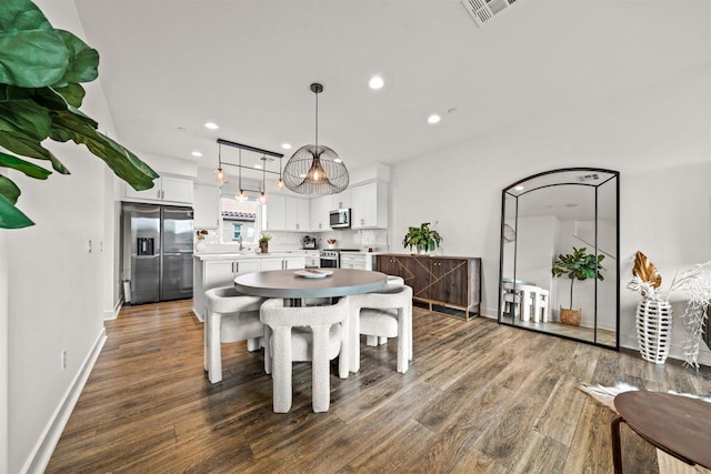 dining room featuring baseboards, dark wood finished floors, visible vents, and recessed lighting