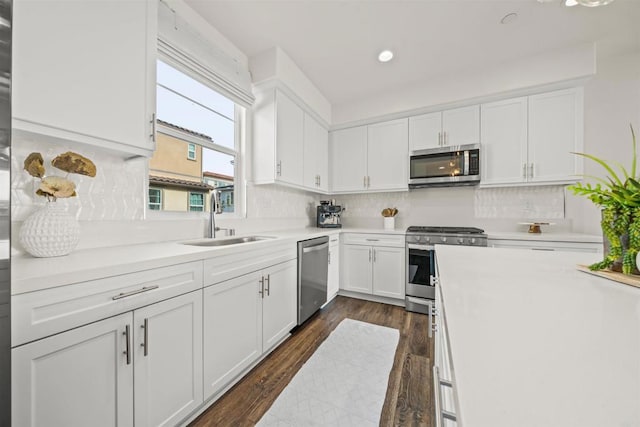 kitchen featuring a sink, white cabinets, light countertops, appliances with stainless steel finishes, and tasteful backsplash