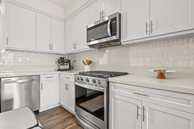 kitchen featuring white cabinets, backsplash, stainless steel appliances, and light countertops