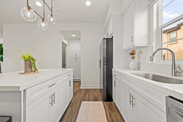 kitchen featuring white cabinets, light countertops, and a sink