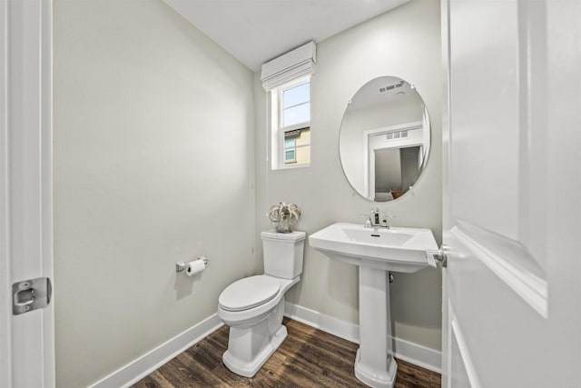 bathroom featuring a sink, wood finished floors, toilet, and baseboards