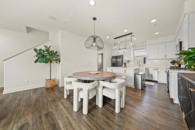 dining room with baseboards, dark wood finished floors, and recessed lighting