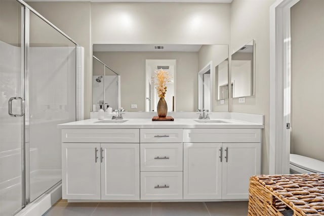 bathroom featuring toilet, a shower stall, visible vents, and a sink