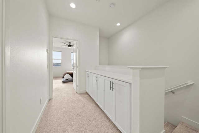 hall with light carpet, baseboards, and recessed lighting